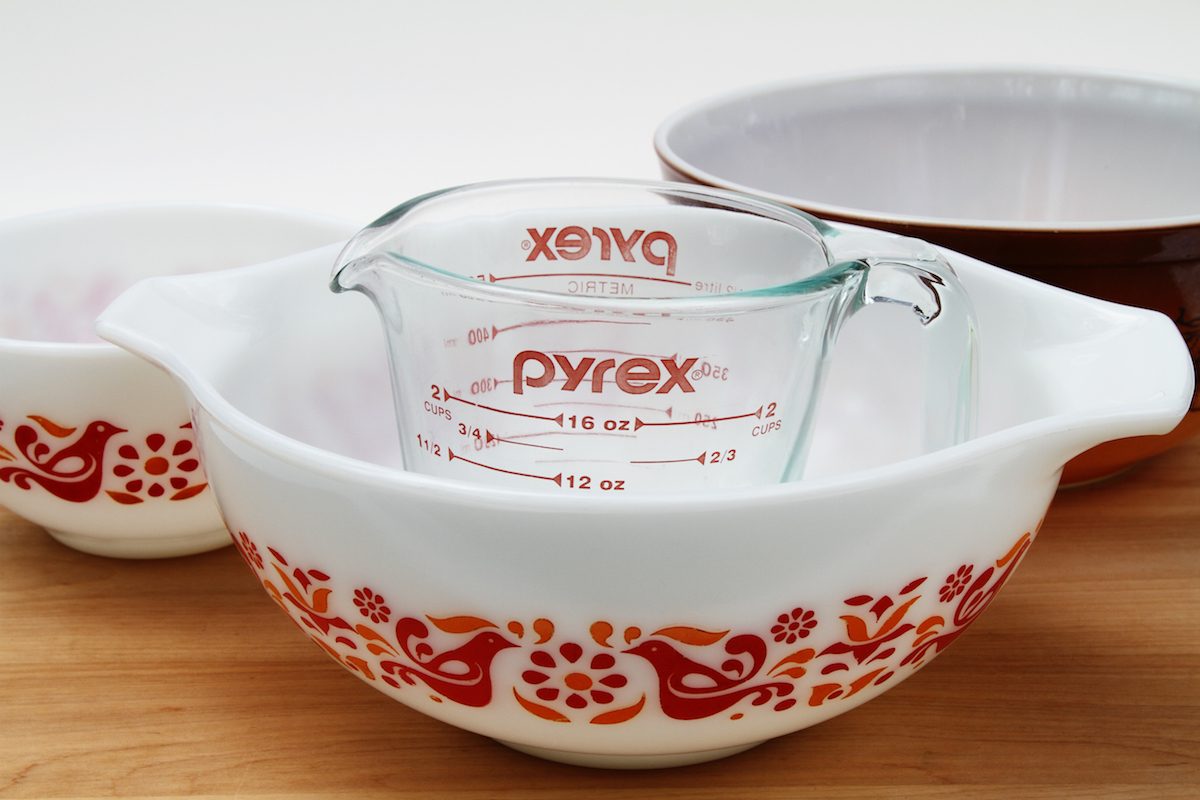 一个PYREX透明玻璃量杯与几个老式的PYREX碗。白色的碗以友谊为特色。耐热玻璃最近庆祝了它自1915年由康宁公司推出以来的100周年纪念日。该品牌现在由康宁的子公司World Kitchen LLC生产。