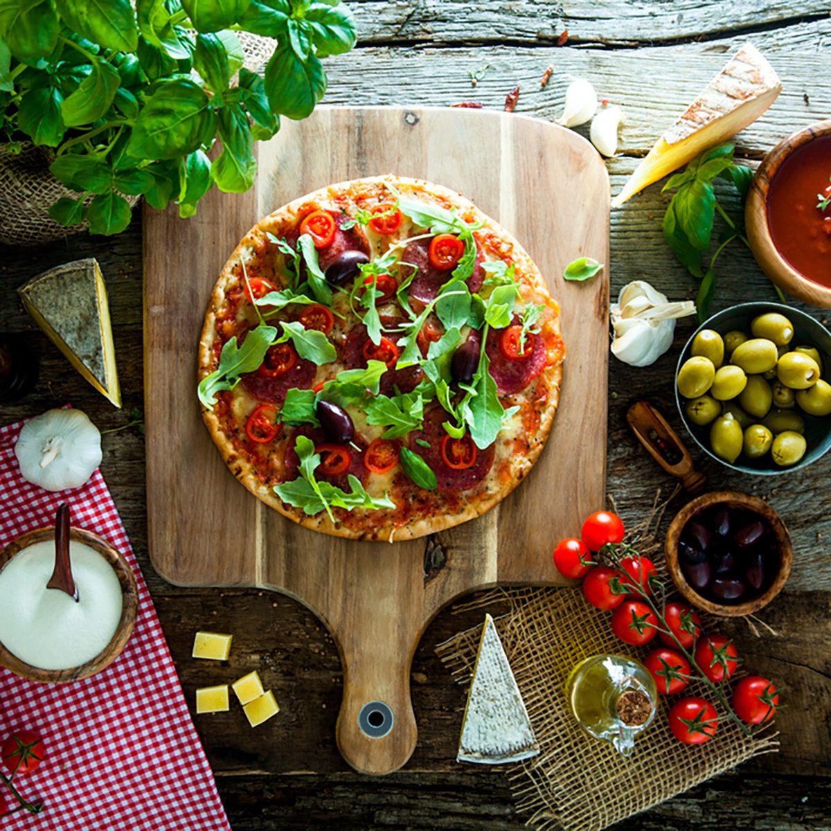 新鲜的意大利木质披萨。披萨加奶酪、意大利腊肠和西红柿。快餐。乡村的披萨