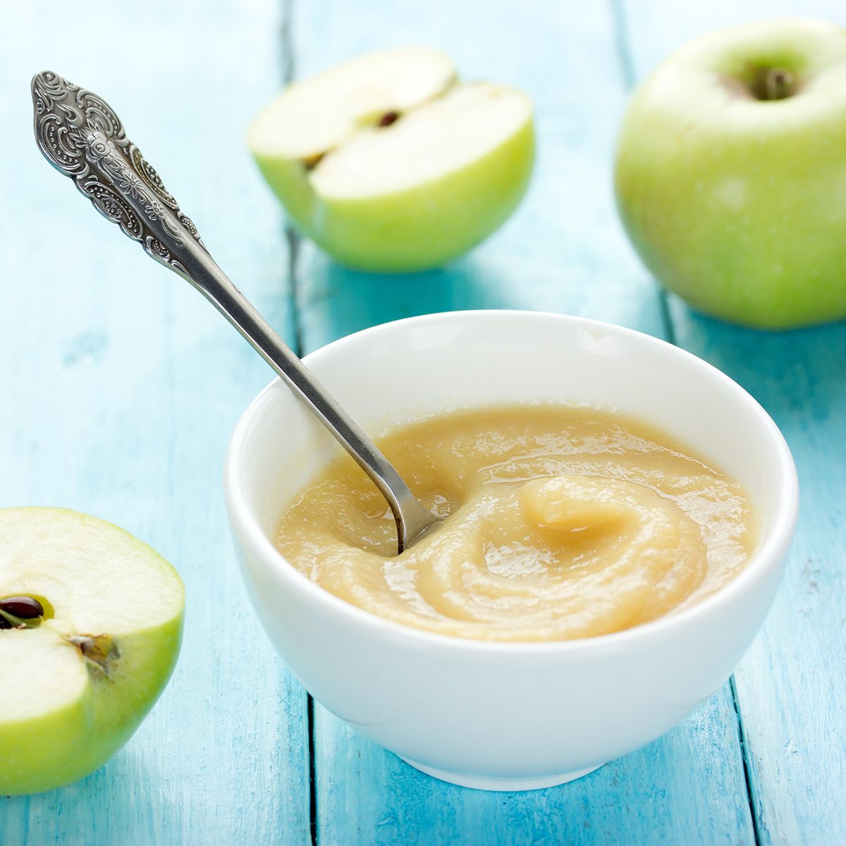 健康的有机苹果酱(苹果泥、慕斯、婴儿食品、酱)在白色碗在桌子上绿色的苹果
