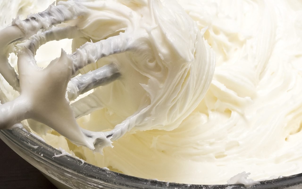 特写奶油芝士糖霜混合在玻璃碗里