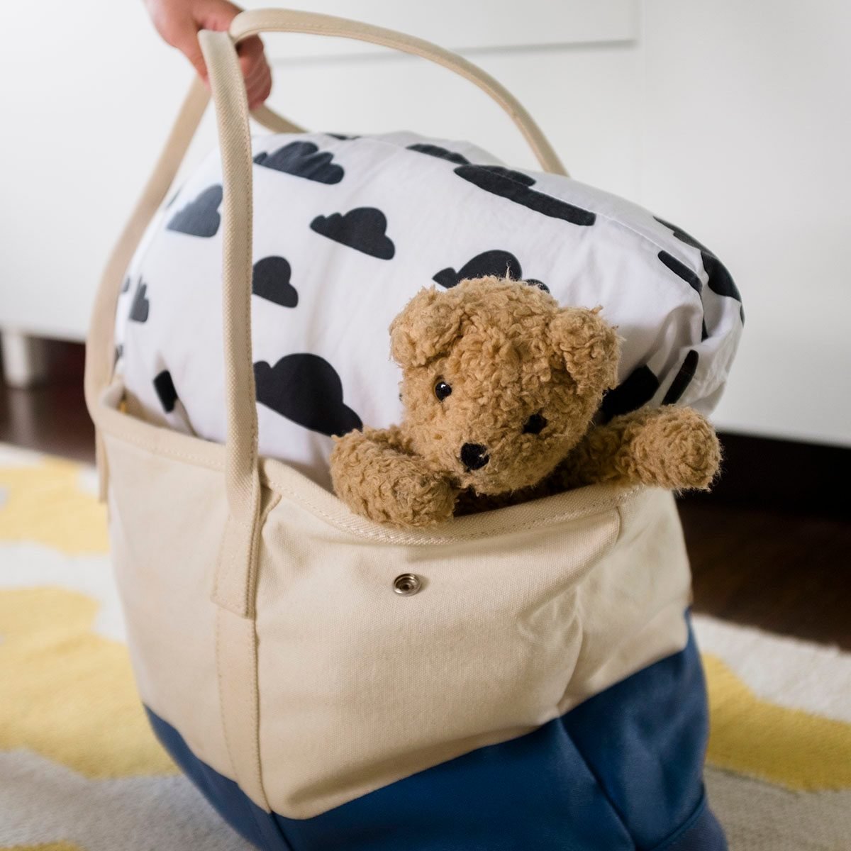 女孩的手拿包与毯子和泰迪熊使用环保袋